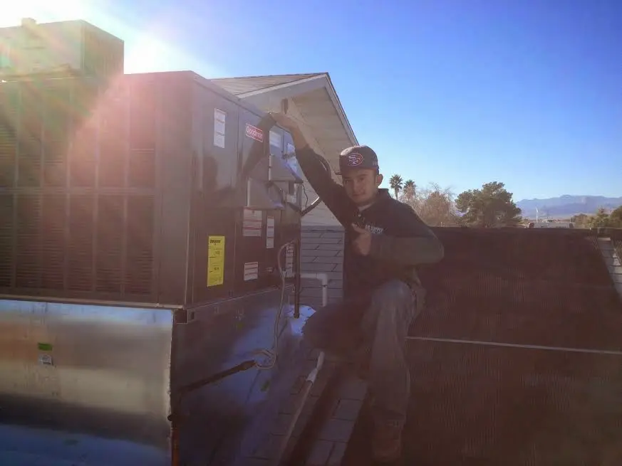 HVAC technician performing HVAC Inspection on a rooftop unit in Corning